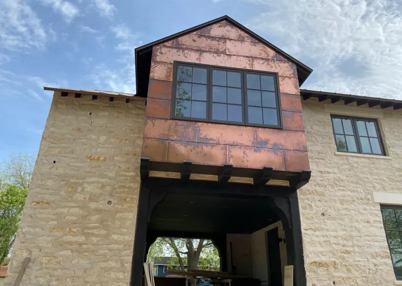 Copper metal panel facade on a stone building for Roof Repair in Wake Village